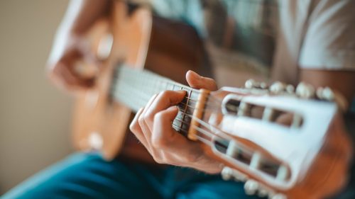 Foto de una persona tocando guitarra acústica